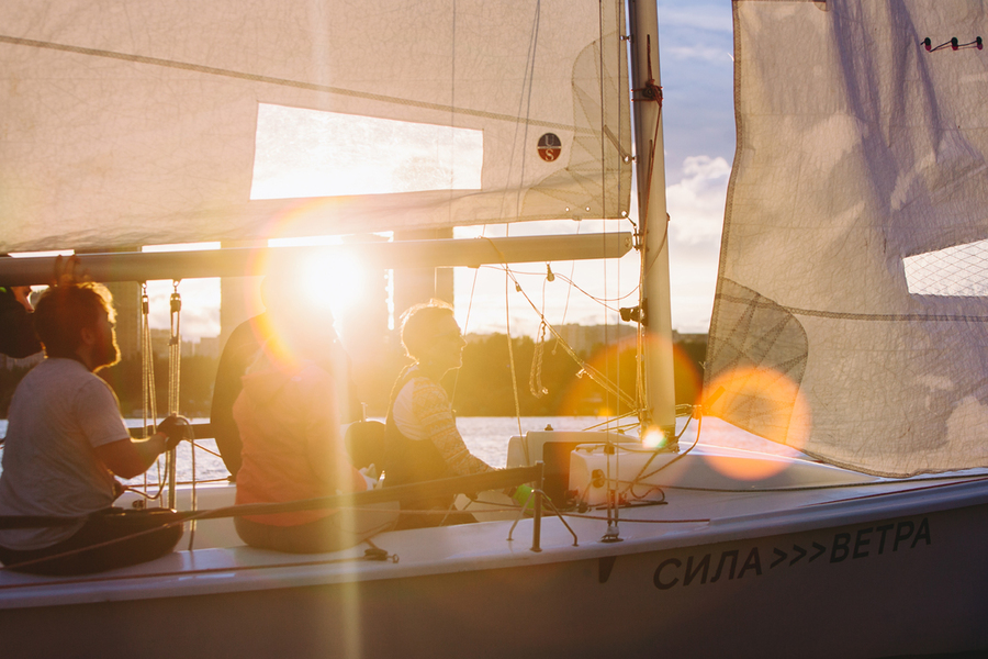 Спортсмены управляют яхтой «Сила ветра» в солнечную погоду