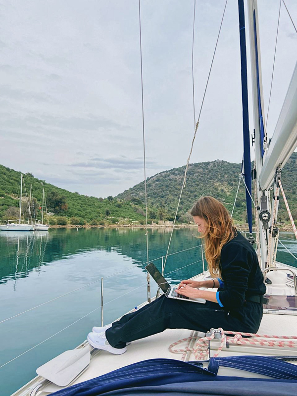 Юлия работает за ноутбуком на яхте в Гечеке